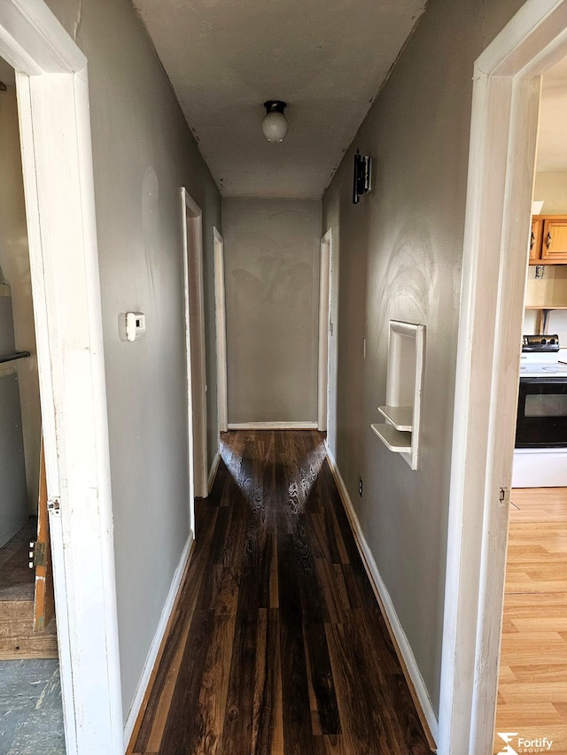 hall with wood finished floors and baseboards