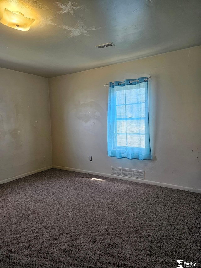 unfurnished room featuring carpet flooring, visible vents, and baseboards