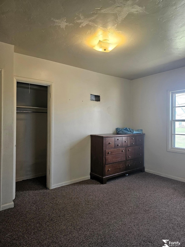 unfurnished bedroom with a closet, baseboards, and carpet floors