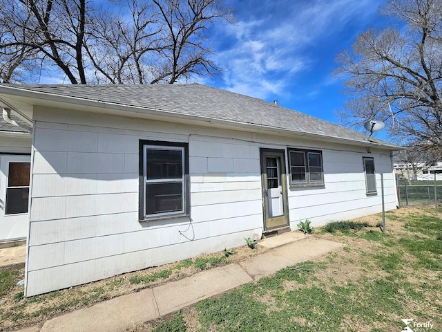 view of front of house with fence and a shingled roof