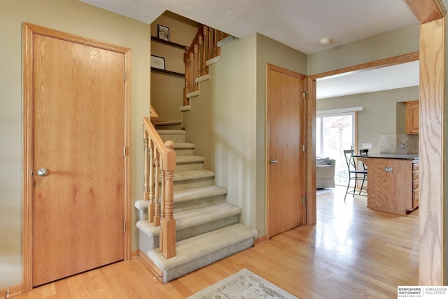 stairs featuring wood finished floors