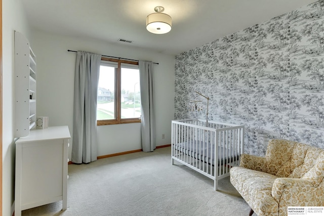 carpeted bedroom featuring baseboards, an accent wall, and visible vents