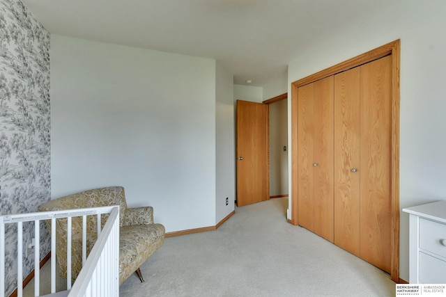 bedroom featuring baseboards, light carpet, and a closet