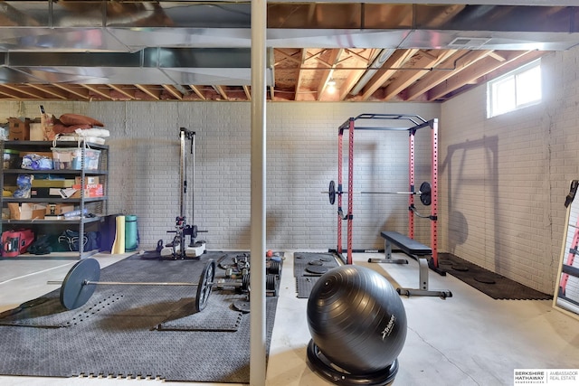 workout area featuring brick wall