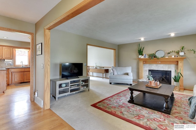 living area featuring a glass covered fireplace, visible vents, and light wood-type flooring