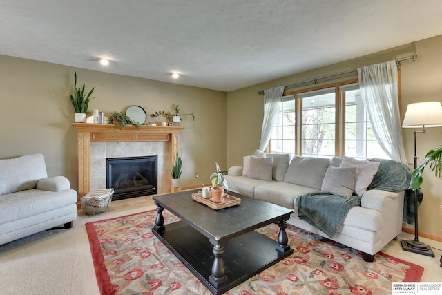 carpeted living area featuring a tile fireplace