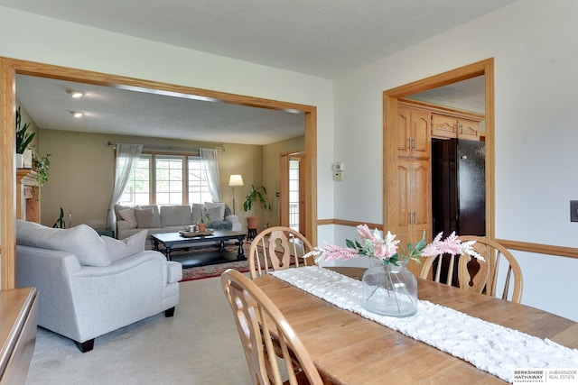 dining area featuring light carpet