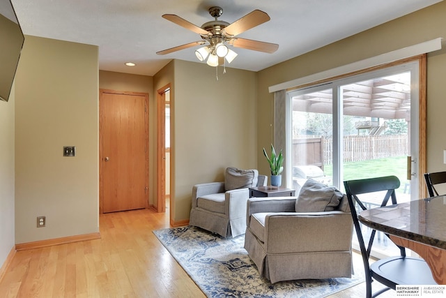 sitting room featuring light wood-style floors, baseboards, and ceiling fan