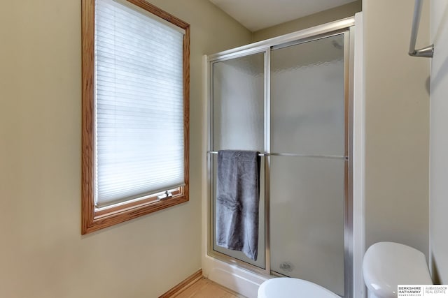 bathroom featuring toilet and a shower stall
