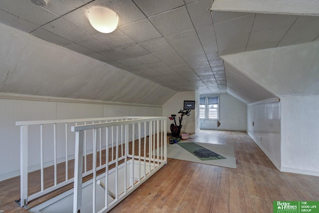 bonus room with lofted ceiling, hardwood / wood-style floors, and baseboards