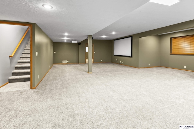 finished below grade area featuring carpet floors, baseboards, stairway, recessed lighting, and a textured ceiling