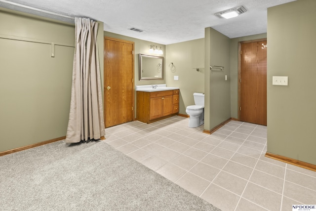 full bathroom with toilet, baseboards, vanity, tile patterned flooring, and a textured ceiling