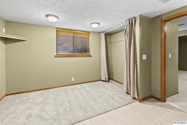 unfurnished bedroom with carpet flooring, baseboards, a closet, and a textured ceiling