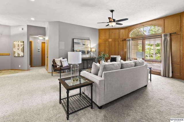 living room featuring a ceiling fan, light carpet, baseboards, recessed lighting, and wooden walls