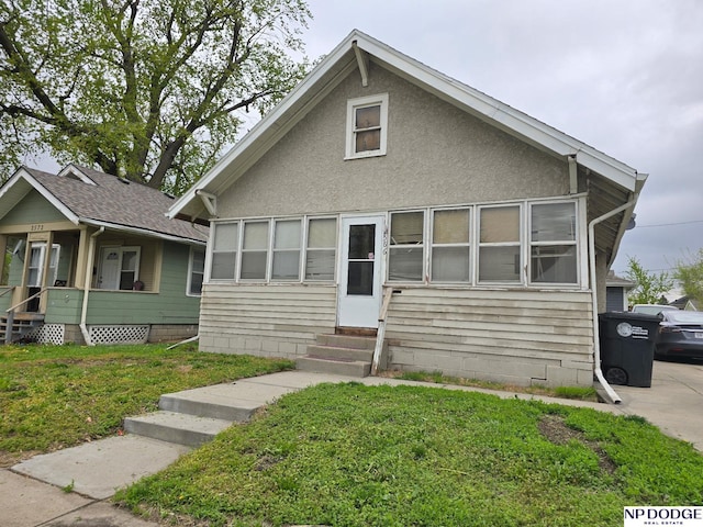 bungalow with entry steps and a front yard