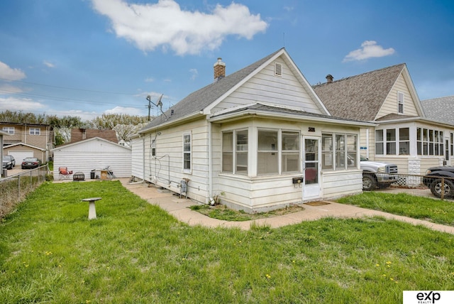 rear view of house featuring a chimney, a yard, fence, a sunroom, and roof with shingles