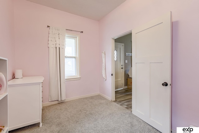 unfurnished bedroom with light colored carpet and baseboards