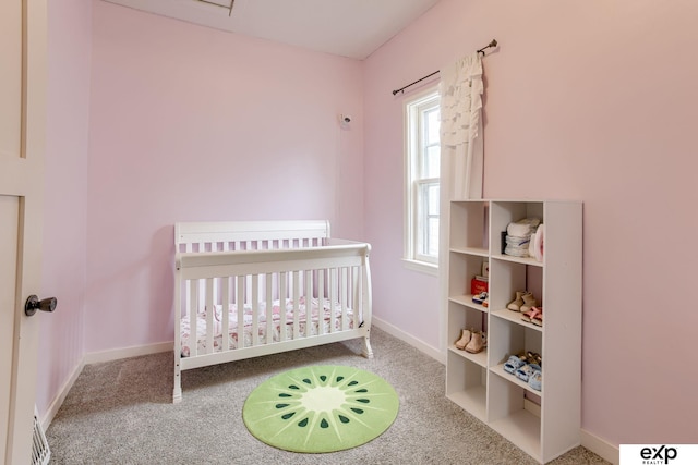 bedroom featuring carpet floors, a nursery area, and baseboards
