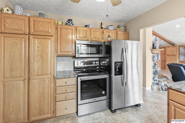 kitchen featuring a textured ceiling, light stone counters, ceiling fan, backsplash, and appliances with stainless steel finishes