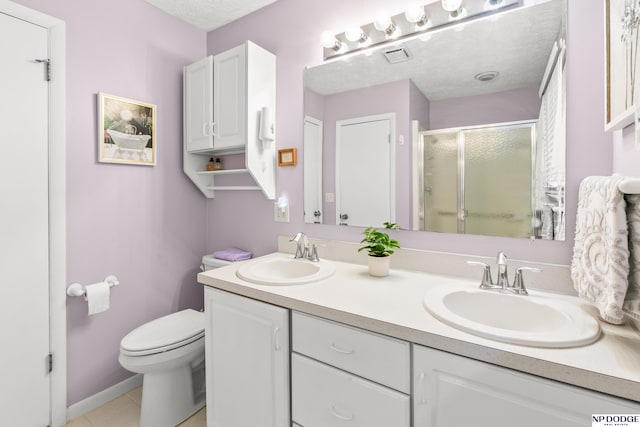bathroom with double vanity, toilet, a shower stall, and a sink