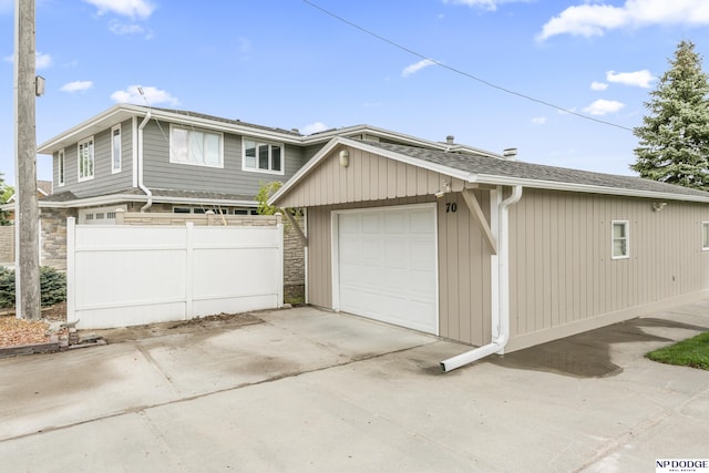 garage featuring fence and driveway