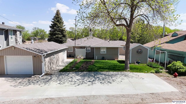 ranch-style house with roof with shingles, a front lawn, and a garage