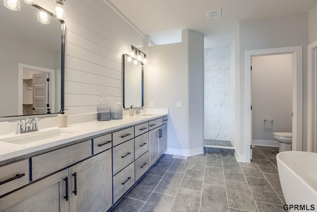 bathroom featuring double vanity, a sink, tiled shower, and visible vents