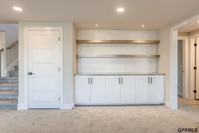 kitchen featuring recessed lighting, open shelves, white cabinets, and light colored carpet