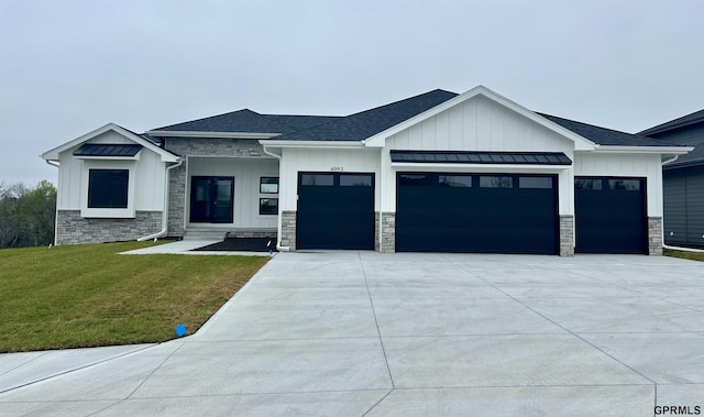 view of front of property featuring a front yard, stone siding, board and batten siding, concrete driveway, and an attached garage