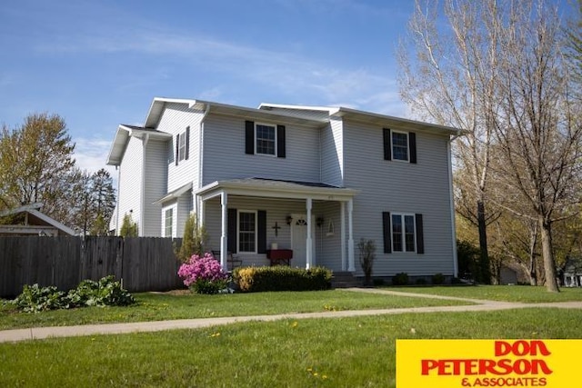 view of front of house with covered porch, fence, and a front yard