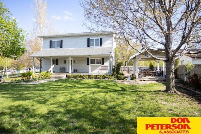 view of front of home featuring fence, covered porch, and a front yard