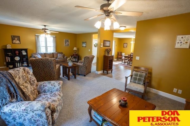 carpeted living room featuring a ceiling fan and baseboards
