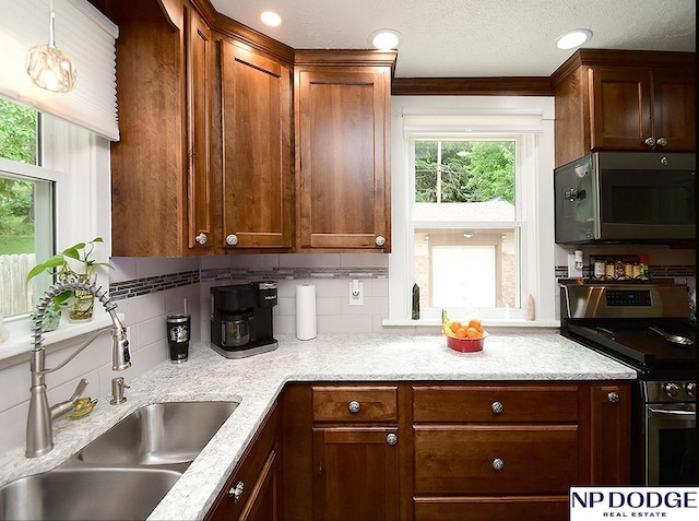 3615 N 60th St, Omaha, NE 68104 - kitchen featuring stainless steel range with electric cooktop, tasteful backsplash, light stone counters, and pendant lighting