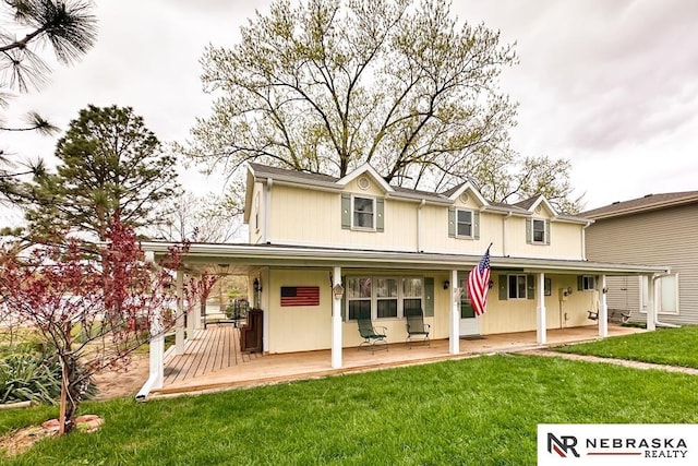 rear view of property featuring a yard and a porch