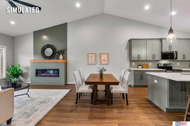kitchen featuring open floor plan, light countertops, gray cabinets, tasteful backsplash, and stainless steel appliances