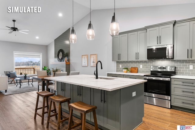 kitchen featuring a sink, gray cabinets, high vaulted ceiling, and stainless steel appliances