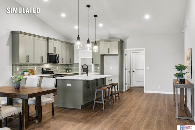 kitchen featuring a sink, light countertops, gray cabinets, stainless steel appliances, and decorative backsplash