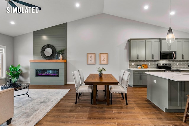 kitchen featuring appliances with stainless steel finishes, light countertops, open floor plan, backsplash, and gray cabinetry