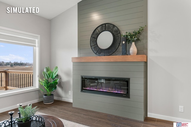 living room featuring baseboards, wood finished floors, and a fireplace