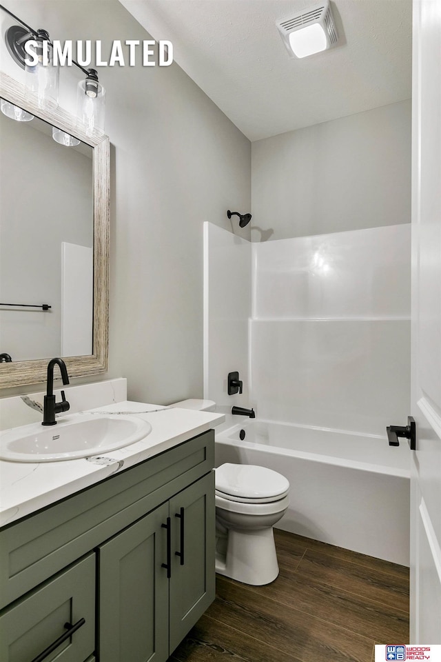 bathroom with visible vents, wood finished floors, vanity, toilet, and shower / bathtub combination