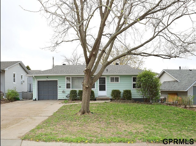 single story home with concrete driveway, an attached garage, entry steps, and a front lawn