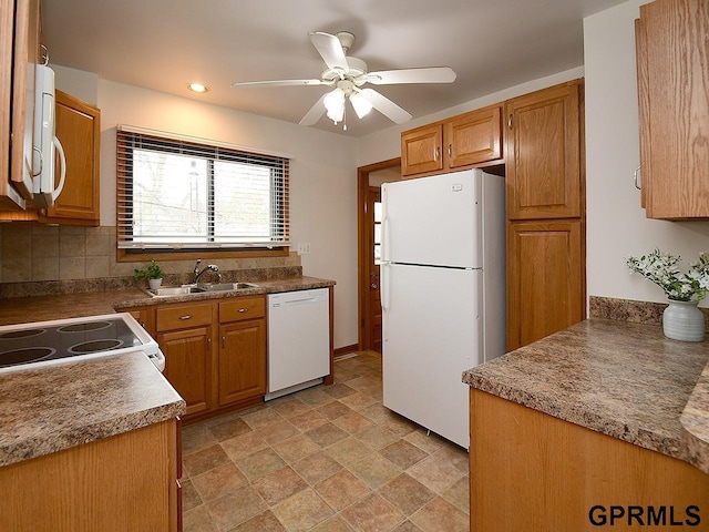 kitchen with stone finish floor, a ceiling fan, tasteful backsplash, a sink, and white appliances