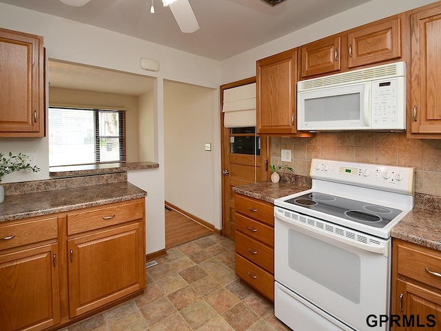 kitchen with white appliances, backsplash, a ceiling fan, and brown cabinetry