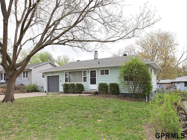 view of front of home featuring concrete driveway, a chimney, a front lawn, and a garage