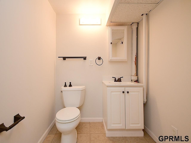 bathroom featuring toilet, baseboards, tile patterned flooring, and vanity