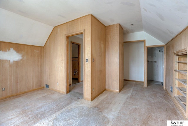 bonus room featuring wood walls and lofted ceiling