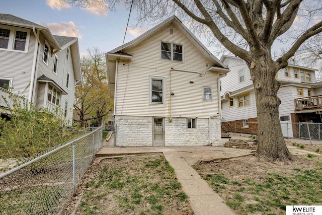 rear view of property featuring a patio and a fenced backyard