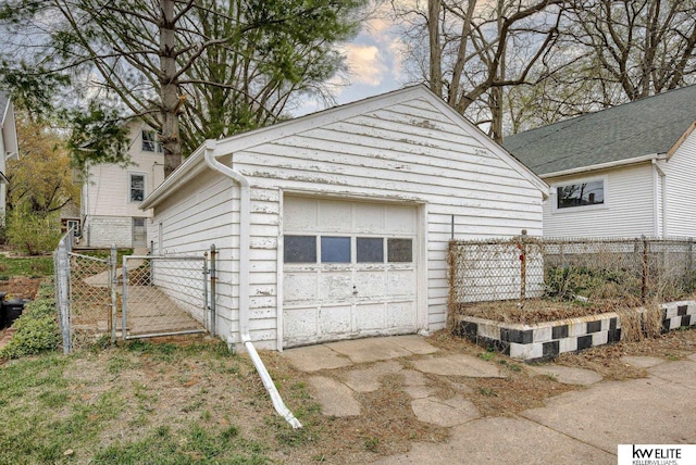 detached garage featuring fence and a gate