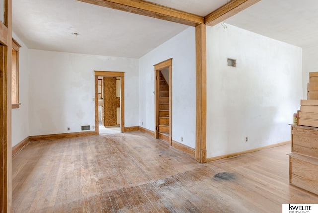 empty room with visible vents, wood finished floors, and baseboards