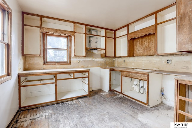 kitchen with light wood finished floors, open shelves, and backsplash